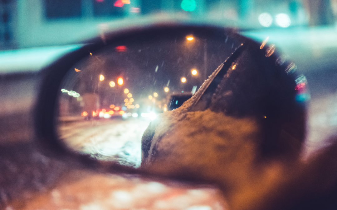 Zijspiegel auto met sneeuw in het donker